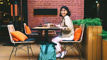 Young woman sitting at a café working and smiling 